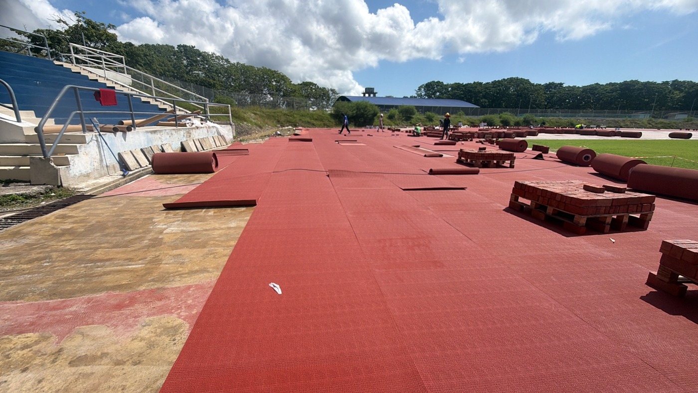 Prefabricated track rolls laid out along the stadium track during installation.